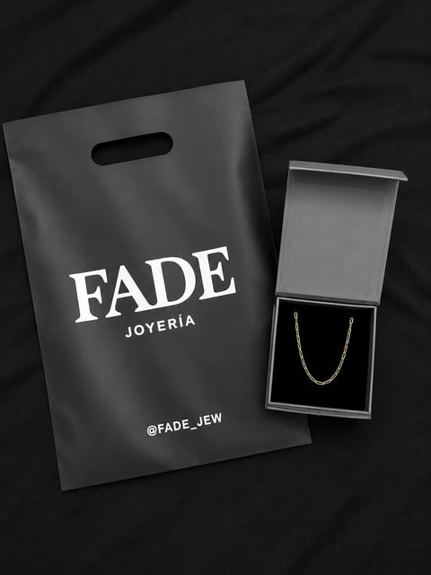 FADE Joyeria jewelry packaging with black branded shopping bag and open gray box containing silver chain necklace on dark background