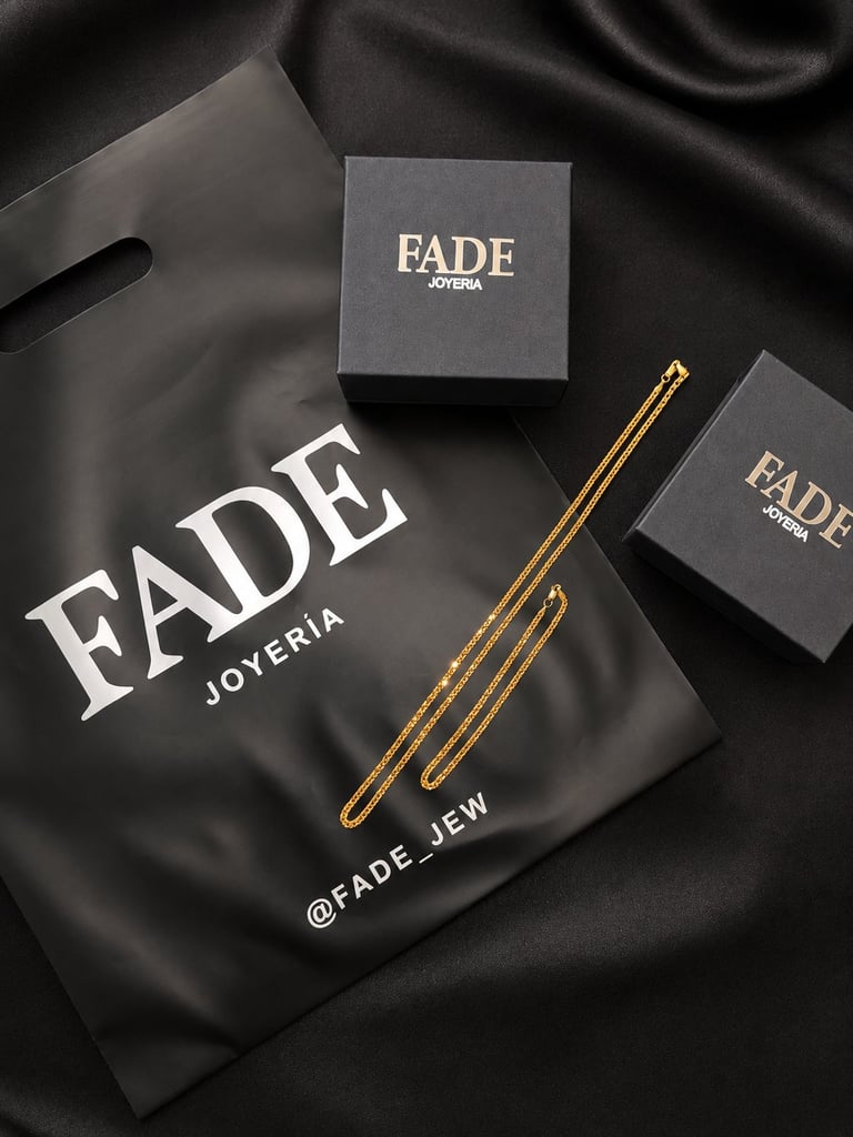 Fade Joyeria jewelry brand packaging displayed with gold earrings and black boxes on dark fabric